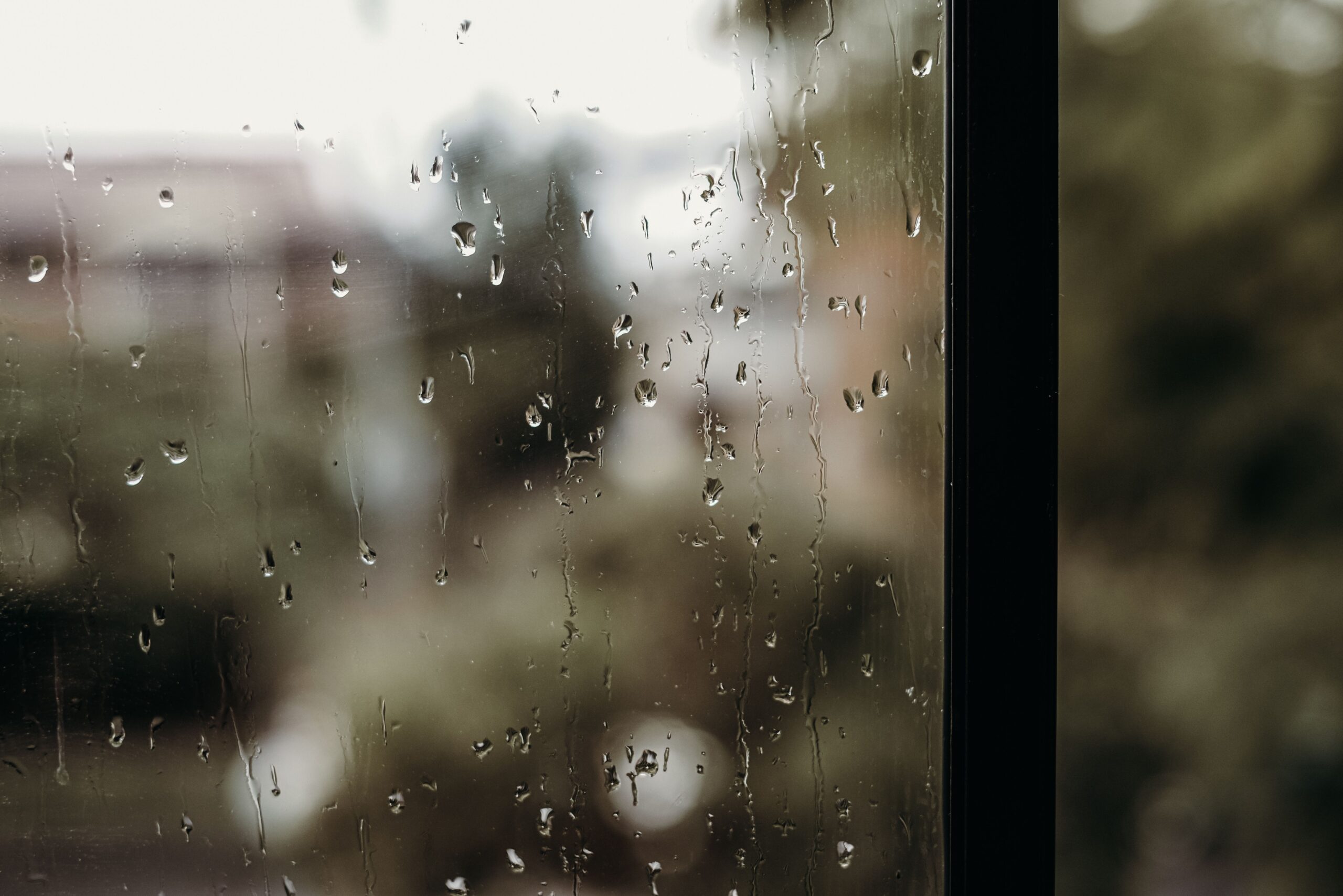 雨粒が付いた窓ガラス越しの景色